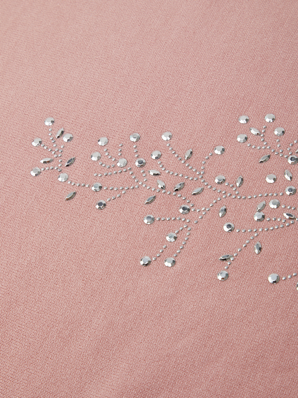 Rhinestone embroidery on a pink fabric background