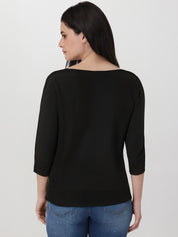 Woman wearing a black top and blue jeans on a white background