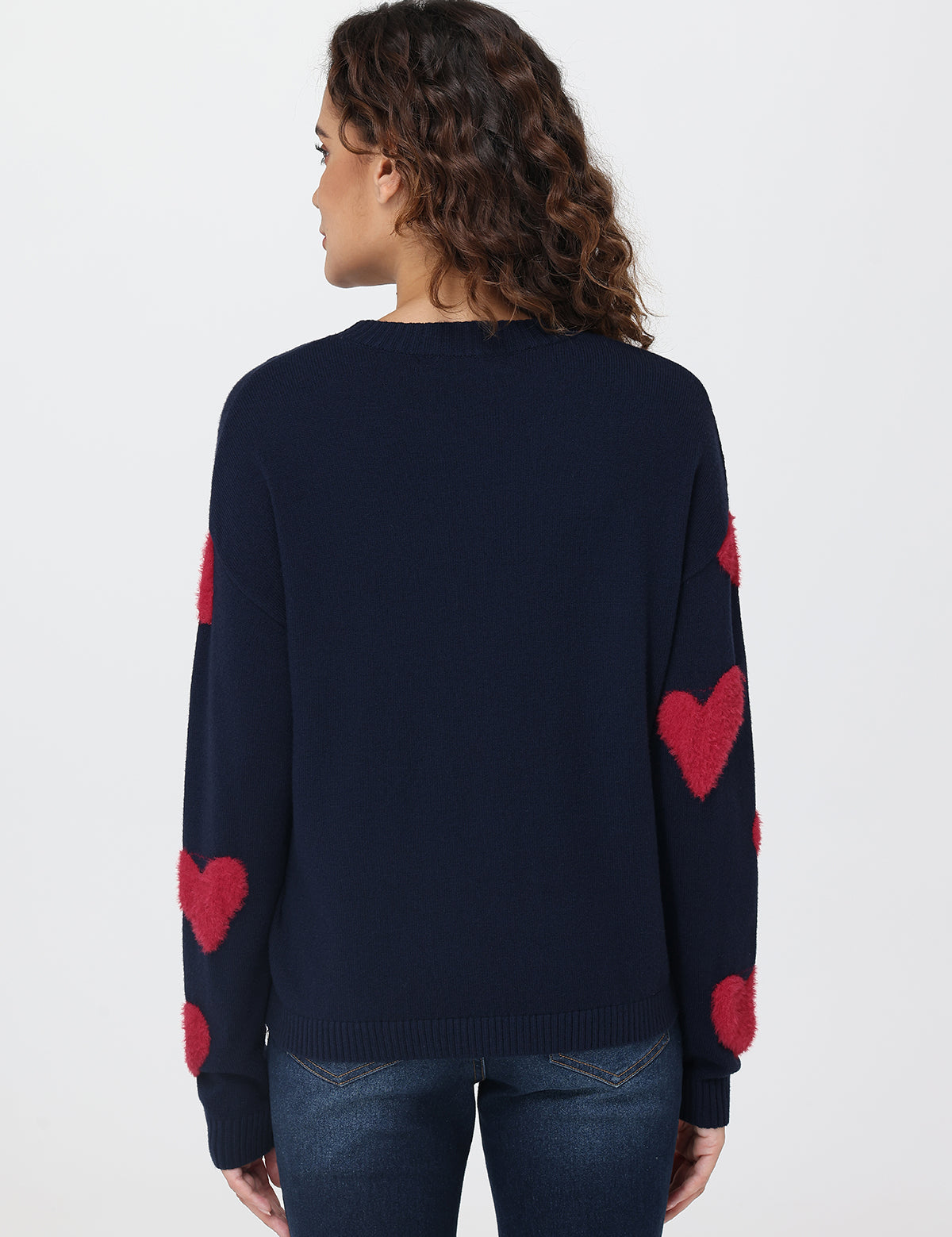 Navy sweater with red heart patterns on a plain background
