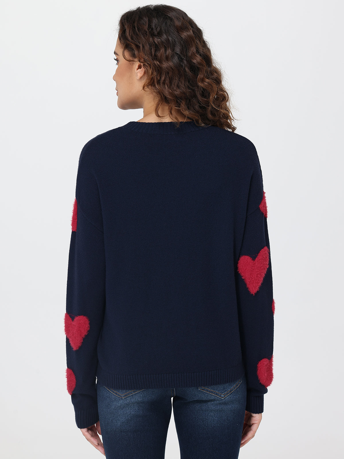 Navy sweater with red heart patterns on a plain background