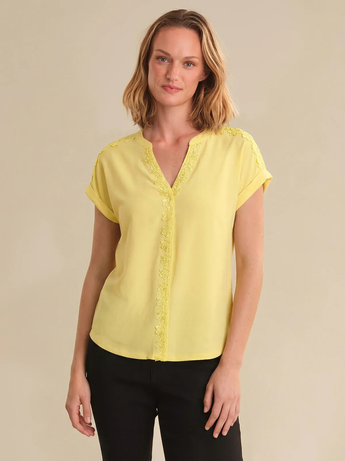 Woman wearing a yellow blouse with a beige background