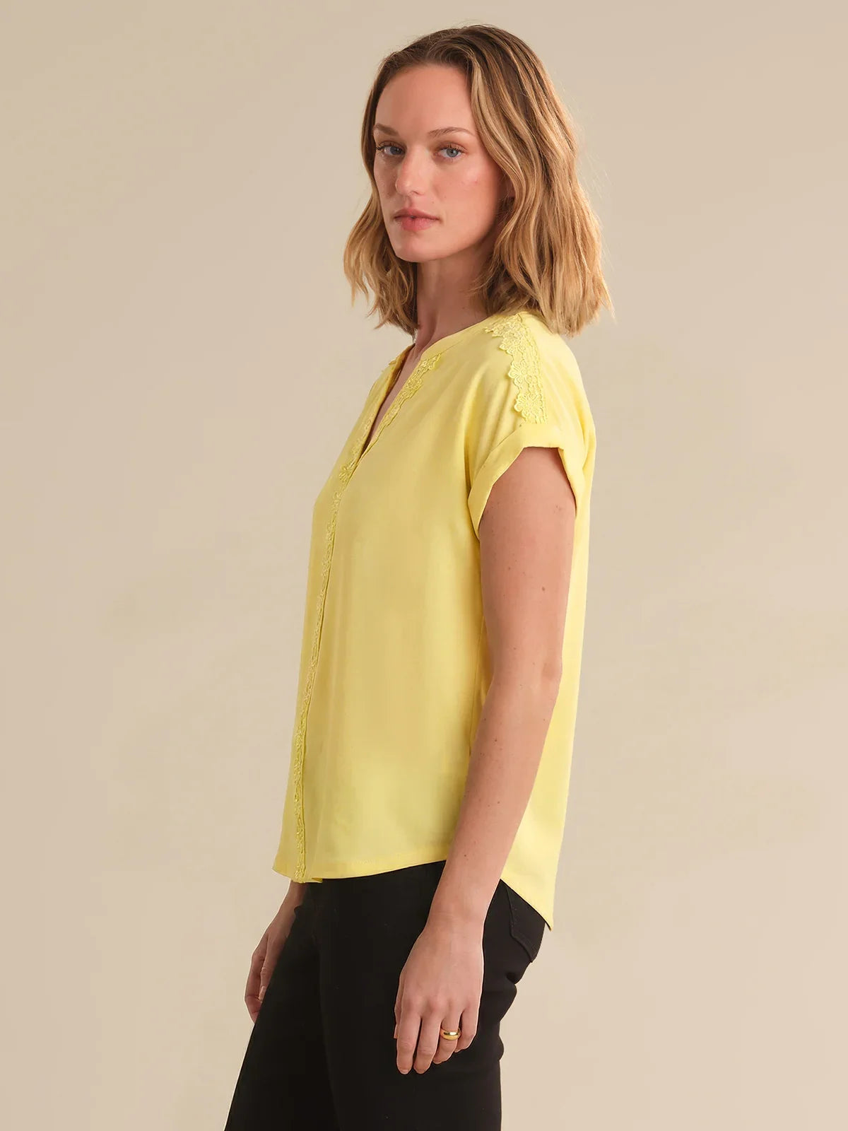 Woman wearing a yellow top against a beige background