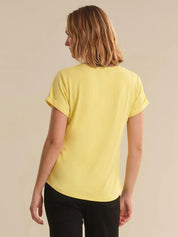 Person wearing a yellow t-shirt on a beige background
