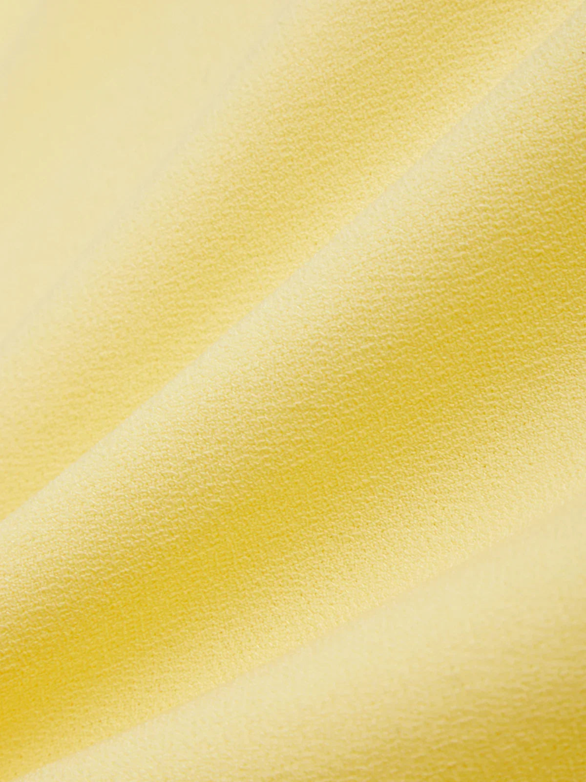 Close-up of yellow fabric with a subtle pattern
