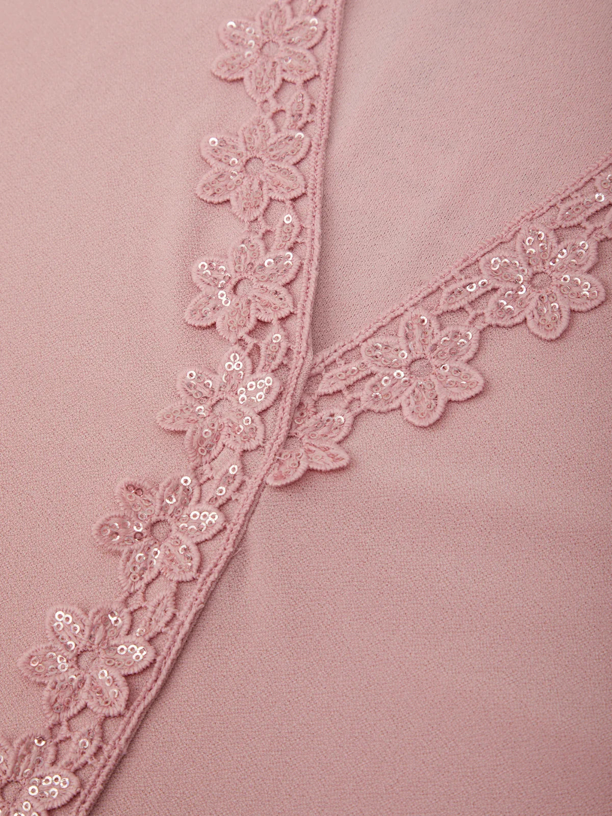 Close-up of a pink fabric with floral lace trim