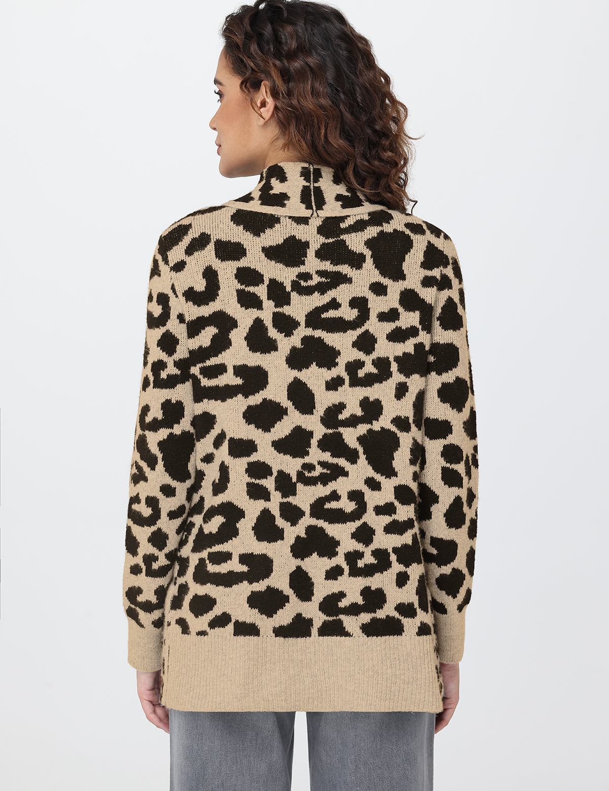 Person wearing a leopard print sweater on a plain background