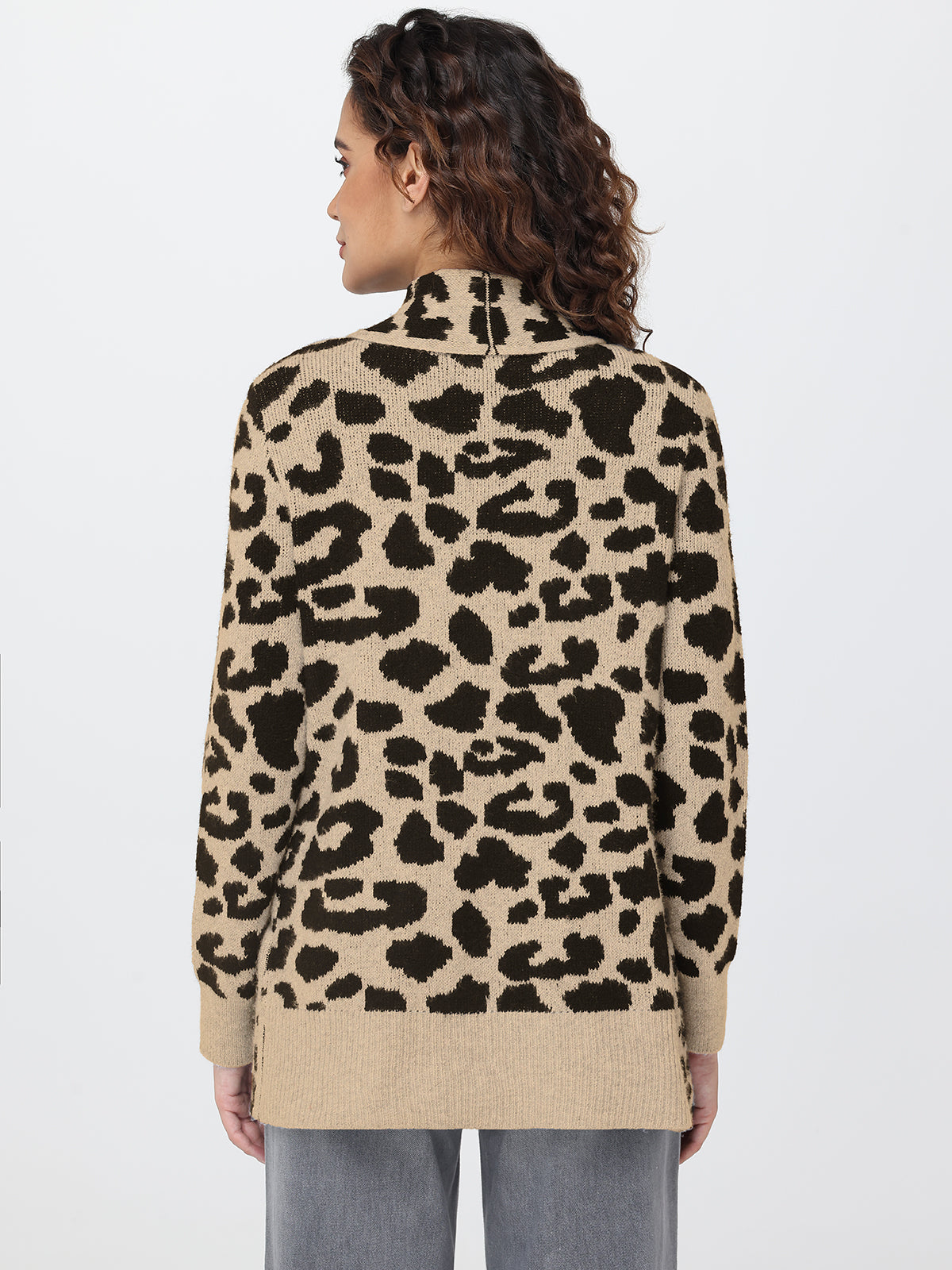 Person wearing a leopard print sweater on a plain background