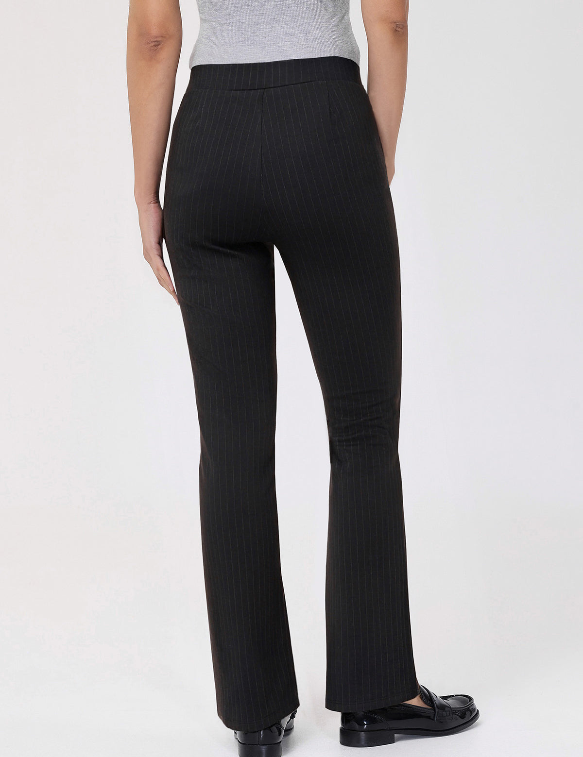 Black pinstripe pants worn by a person on a white background