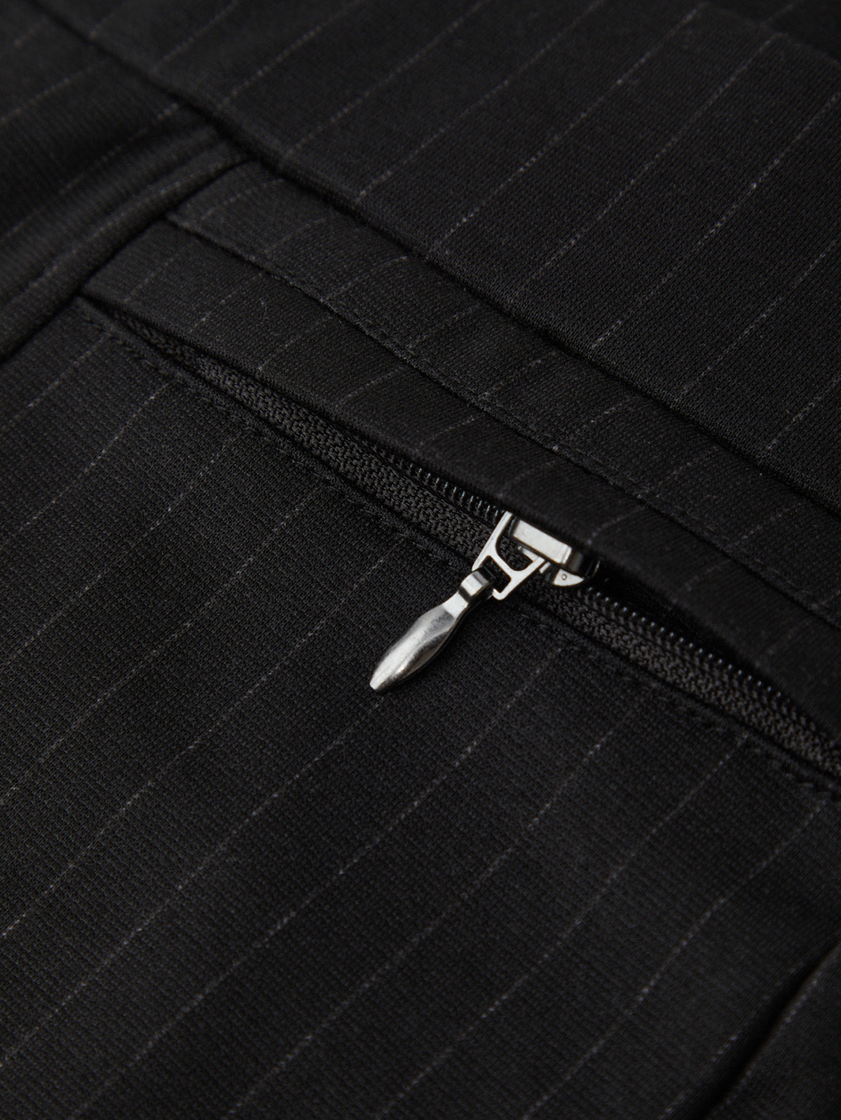 Close-up of a black zipper on a textured fabric background