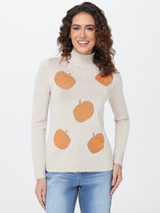 Woman wearing a beige sweater with orange pumpkin patterns on a white background