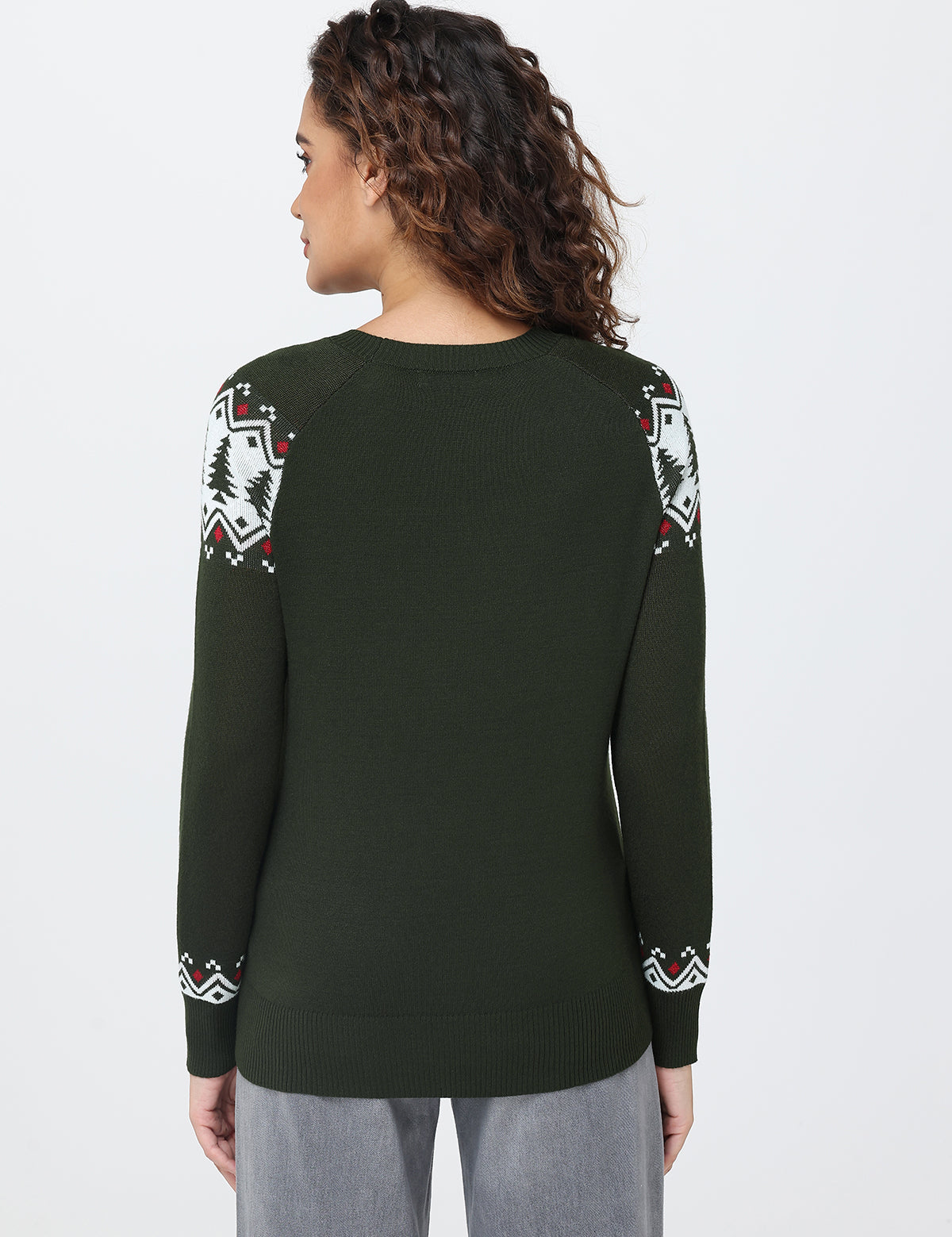 Person wearing a green sweater with patterned sleeves on a white background