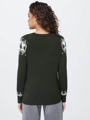 Person wearing a green sweater with patterned sleeves on a white background