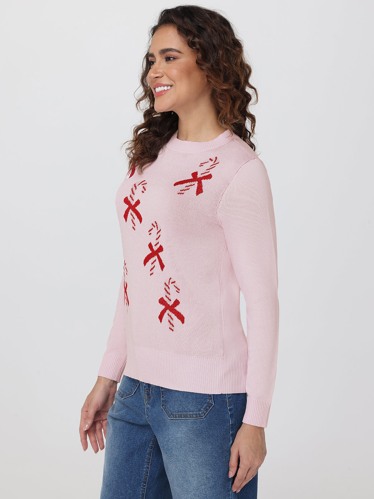 Woman wearing a pink sweater with red patterns on a white background