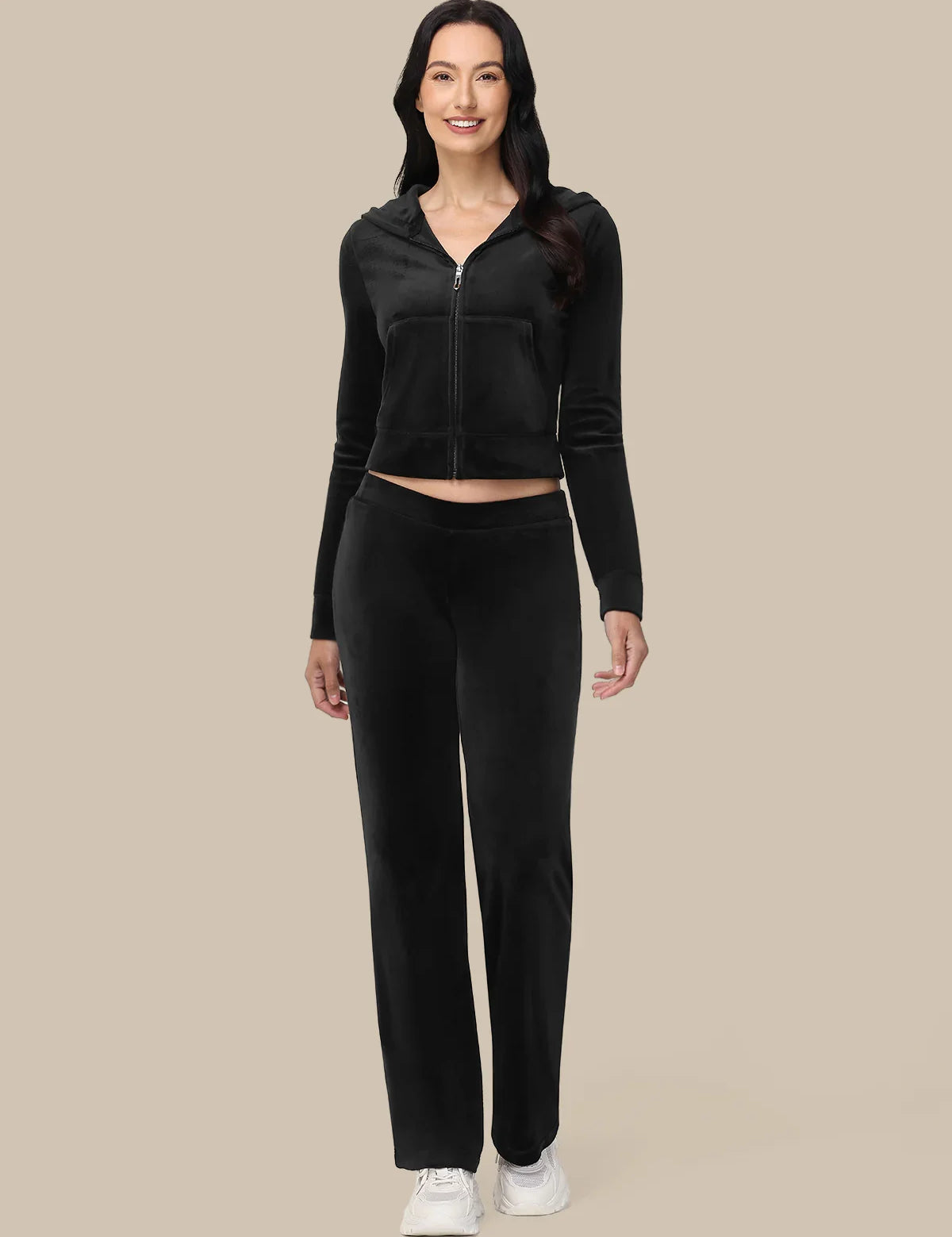 Woman wearing a black tracksuit on a beige background