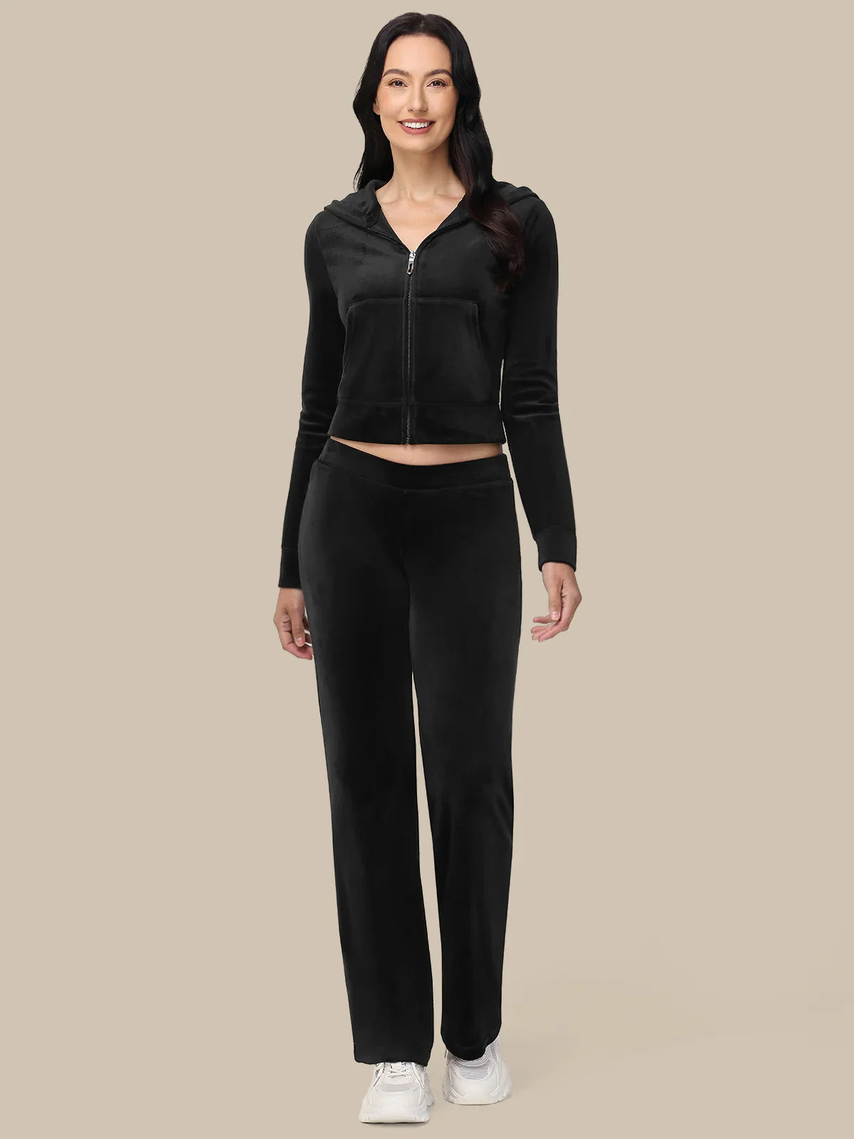 Woman wearing a black tracksuit on a beige background