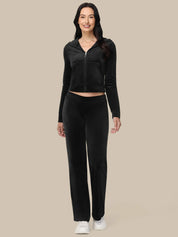 Woman wearing a black tracksuit on a beige background