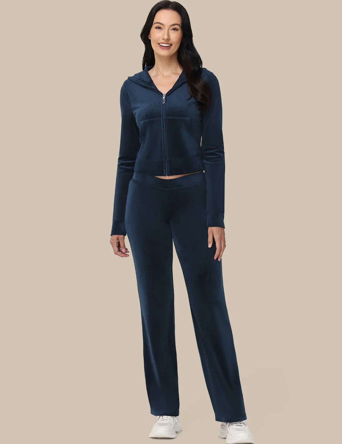 Woman wearing a navy blue tracksuit on a beige background