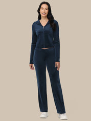 Woman wearing a navy blue tracksuit on a beige background