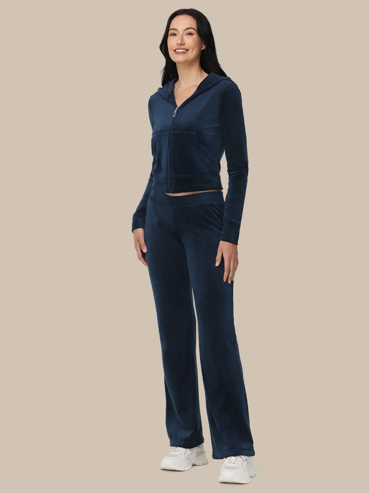 Woman wearing a navy blue tracksuit on a beige background