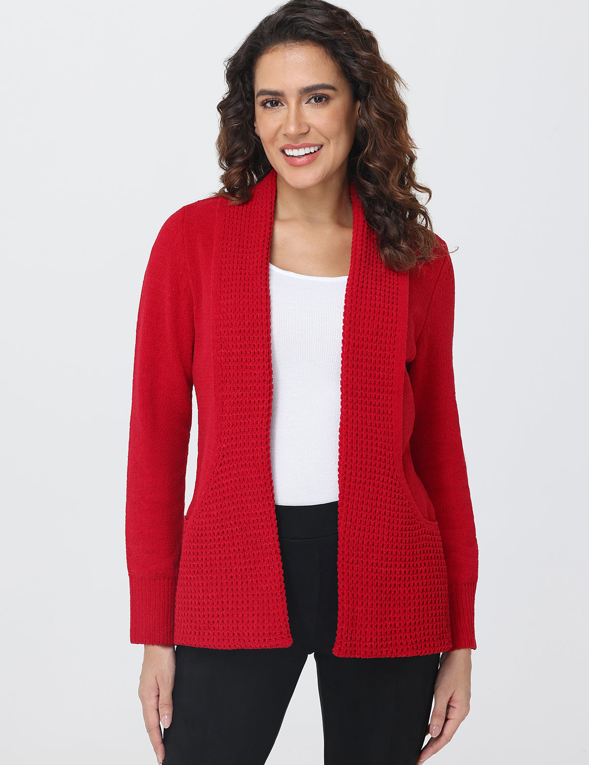 Woman wearing a red cardigan over a white shirt on a plain background