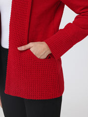 Red knitted cardigan worn by a person on a white background