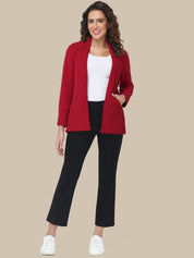 Woman wearing a red blazer, white top, black pants, and white sneakers on a beige background
