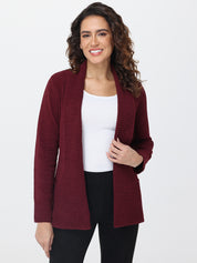 Woman wearing a burgundy cardigan over a white top and black pants on a white background