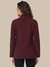 Woman wearing a burgundy sweater against a beige background