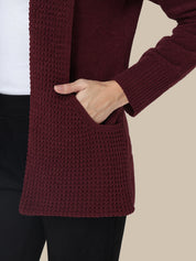 Maroon cardigan worn by a person with a white background