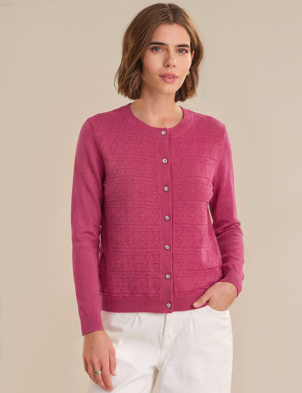 Woman wearing a red cardigan with a subtle pattern on a beige background