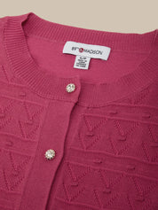 Close-up of a red textured cardigan with '89 & MADISON' label on a beige background