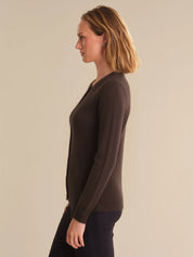 Woman wearing a brown sweater against a beige background