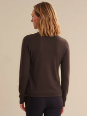 Person wearing a brown sweater on a beige background