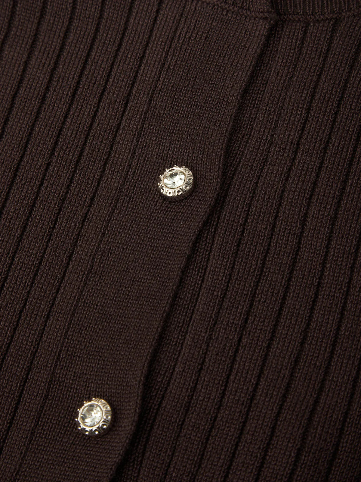Close-up of a ribbed brown sweater with decorative buttons.