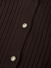 Close-up of a ribbed brown sweater with decorative buttons.