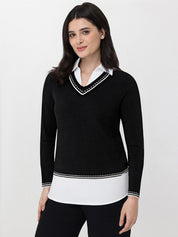 Woman wearing a black sweater with white trim on a white background