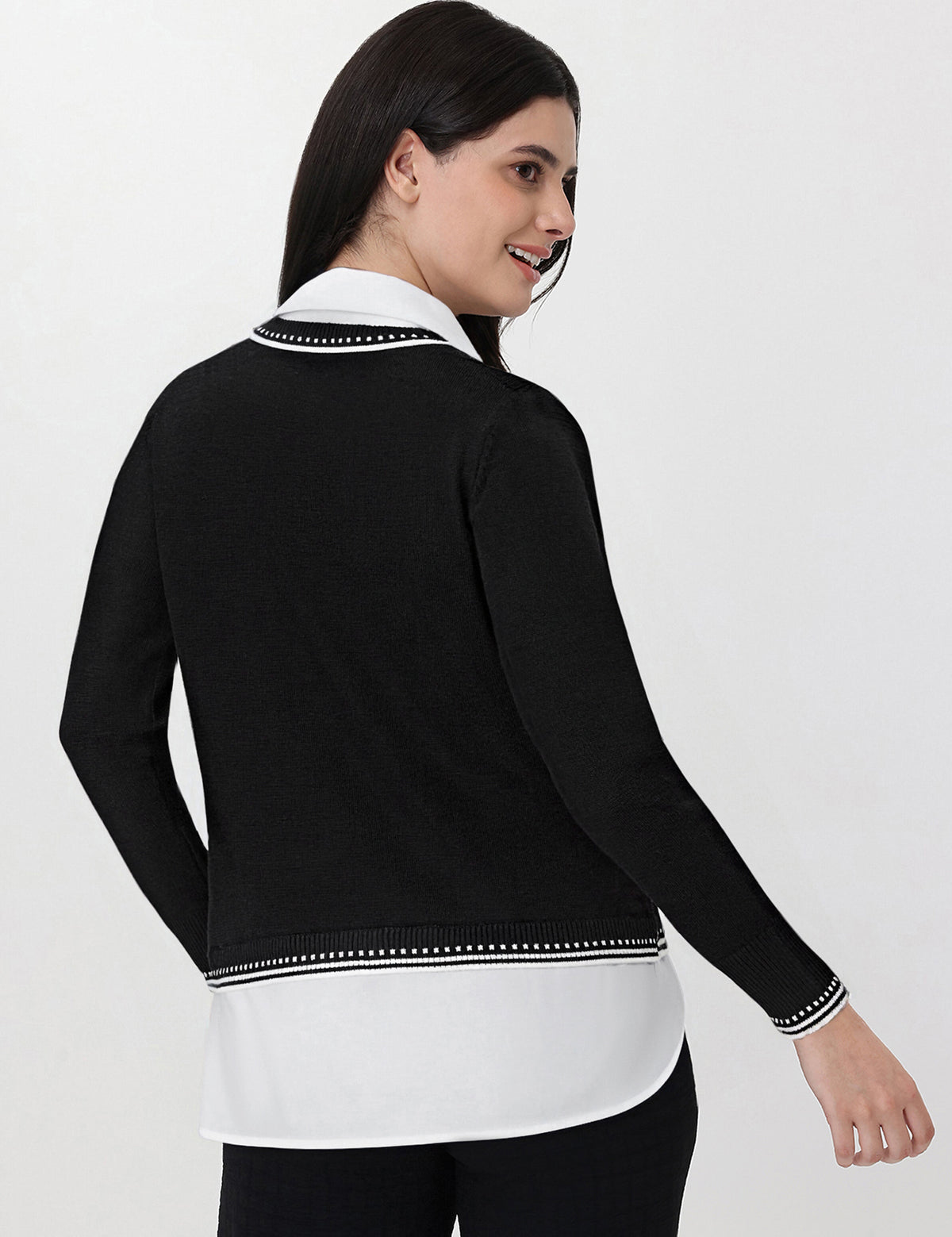 Woman wearing a black and white outfit with a collar on a white background