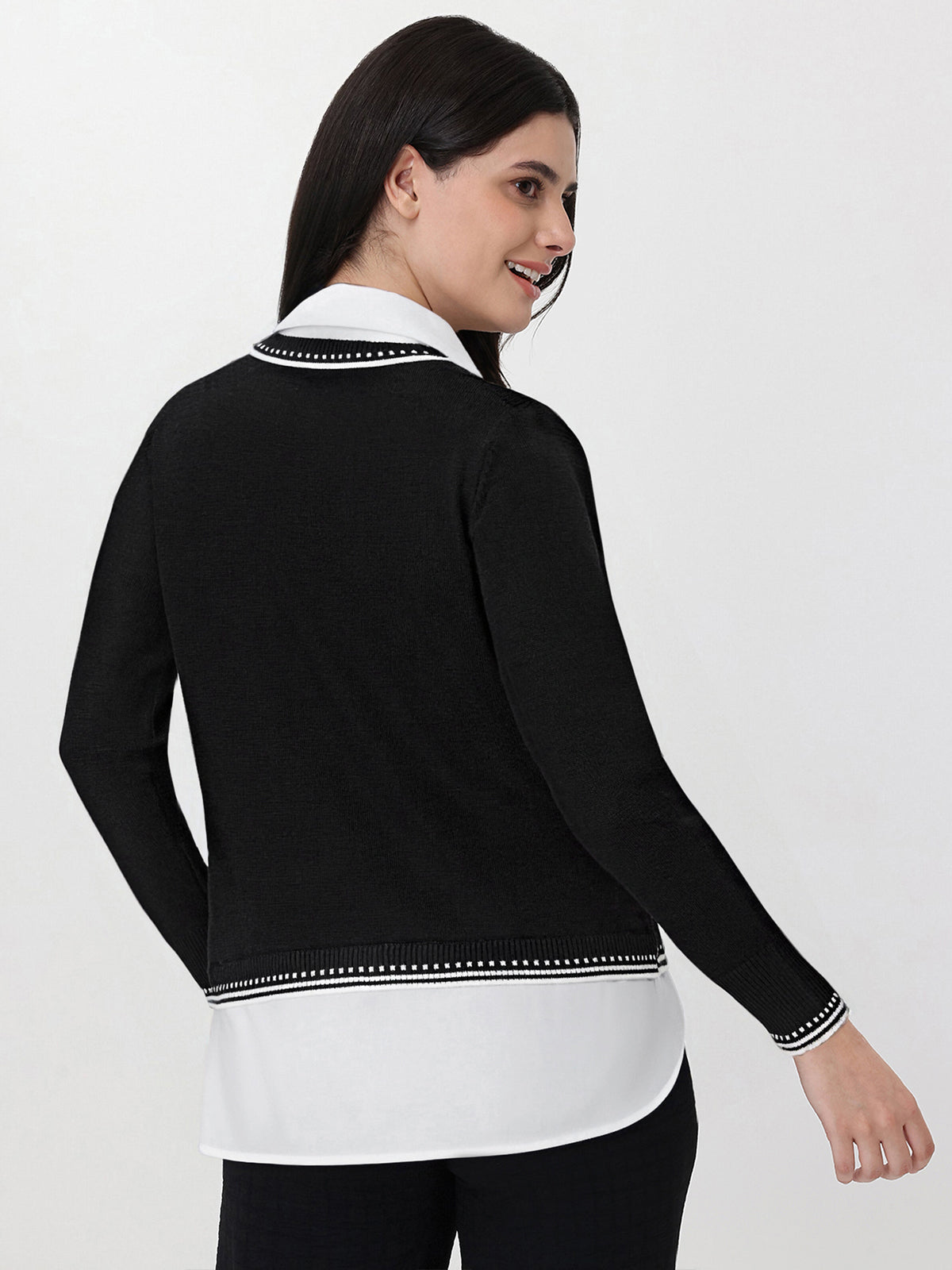 Woman wearing a black and white outfit with a collar on a white background