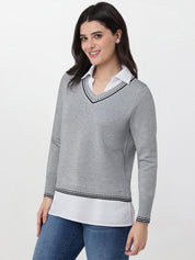 Woman wearing a gray sweater with white collar and trim on a white background