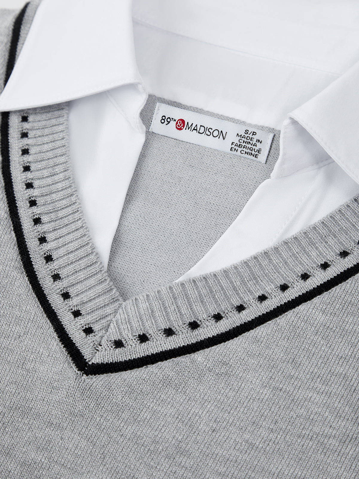 Gray sweater with black trim and a visible brand label on a white background