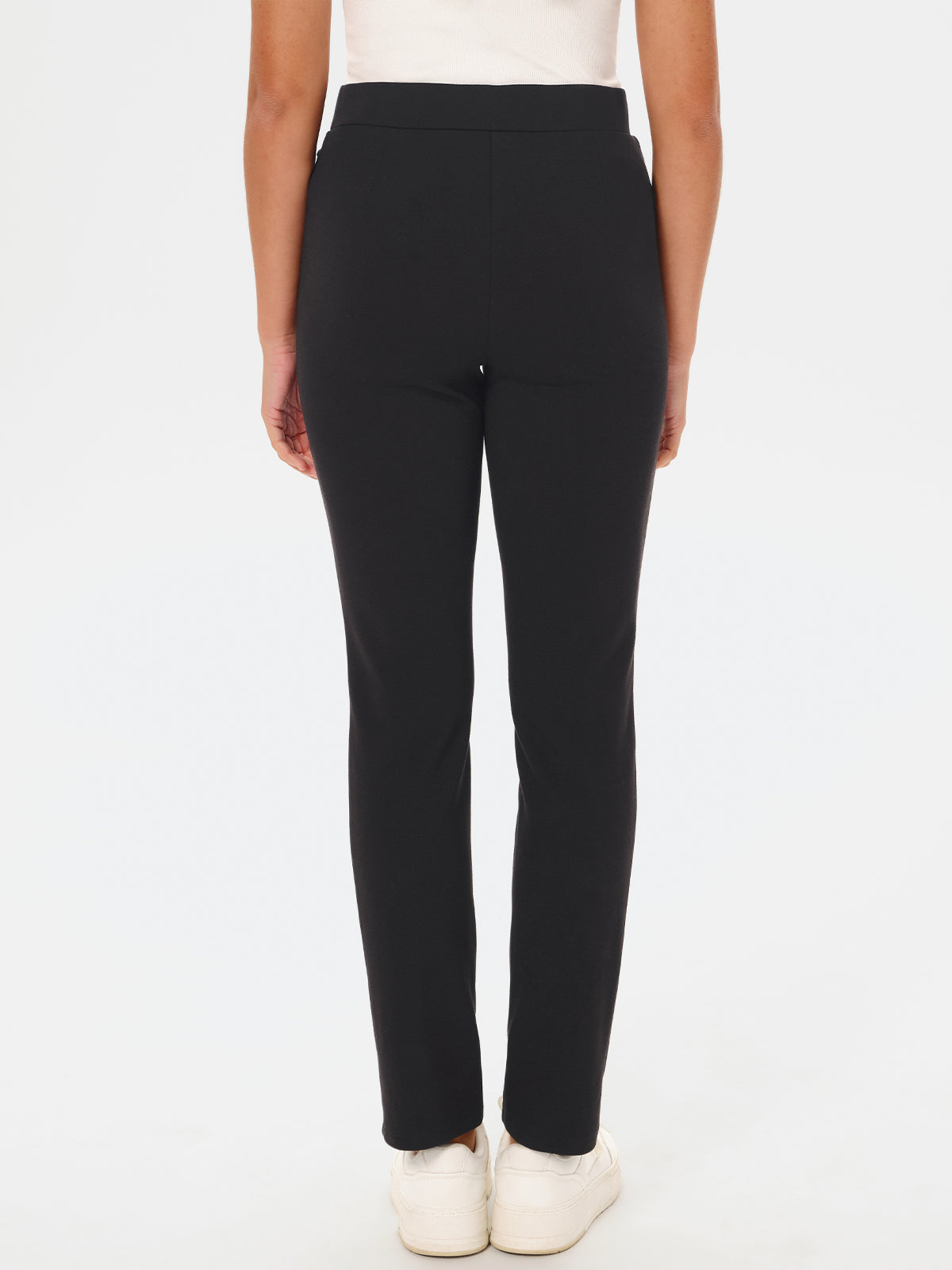 Black pants worn by a person on a white background