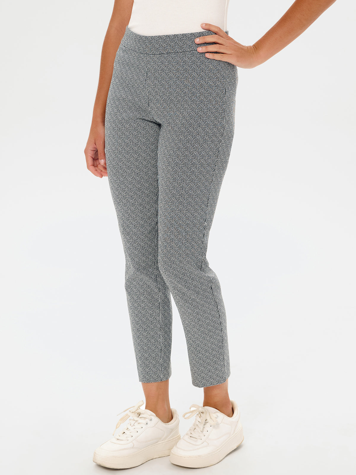 Person wearing gray patterned pants on a white background