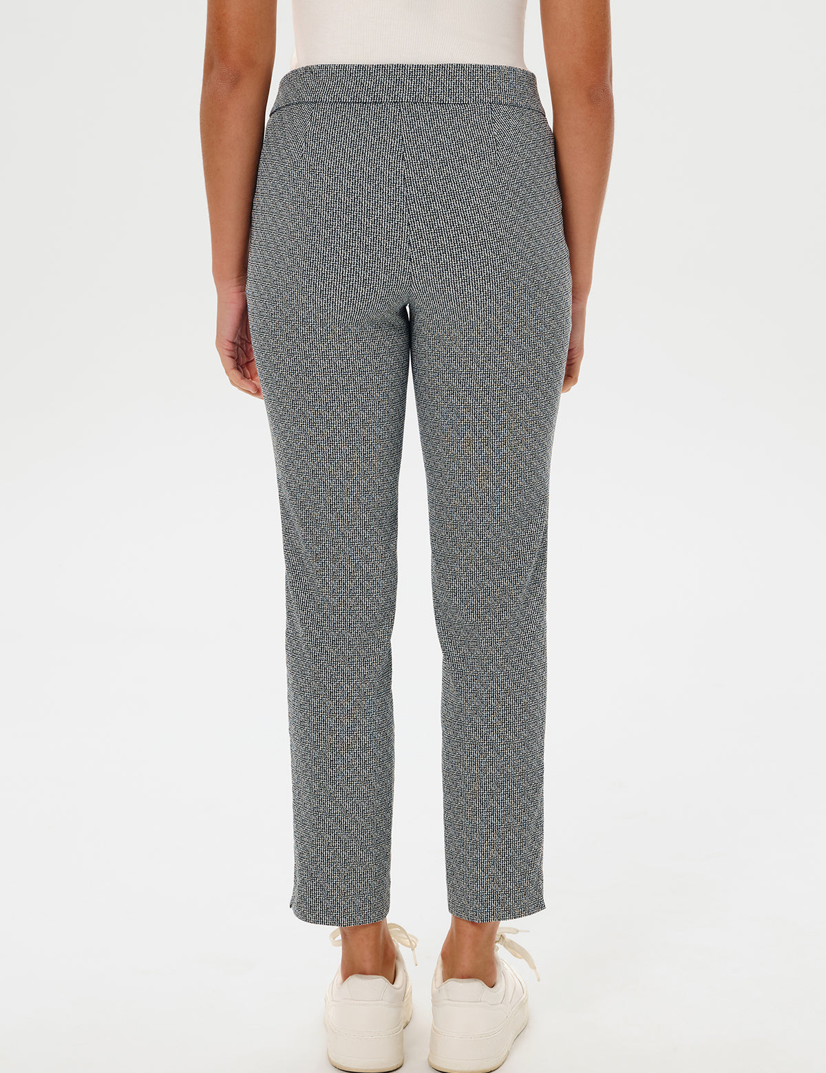 Person wearing gray patterned pants on a white background