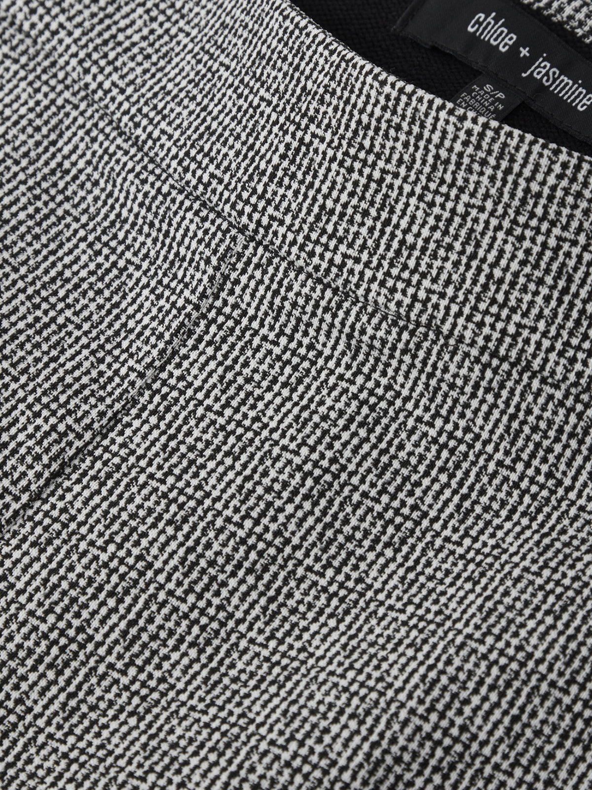 Close-up of a textured gray fabric with a brand label in the corner.