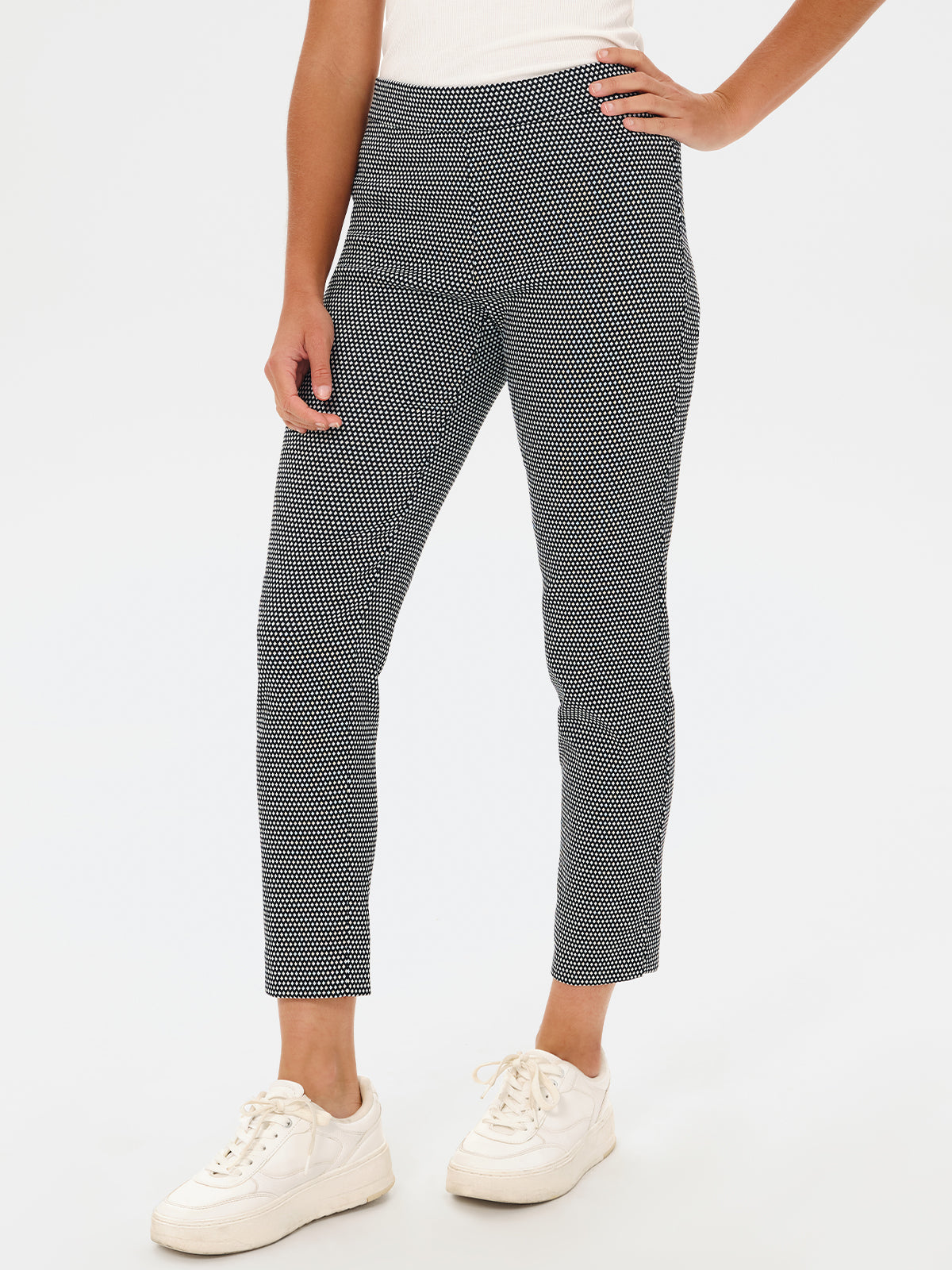 Person wearing black and white checkered pants on a white background