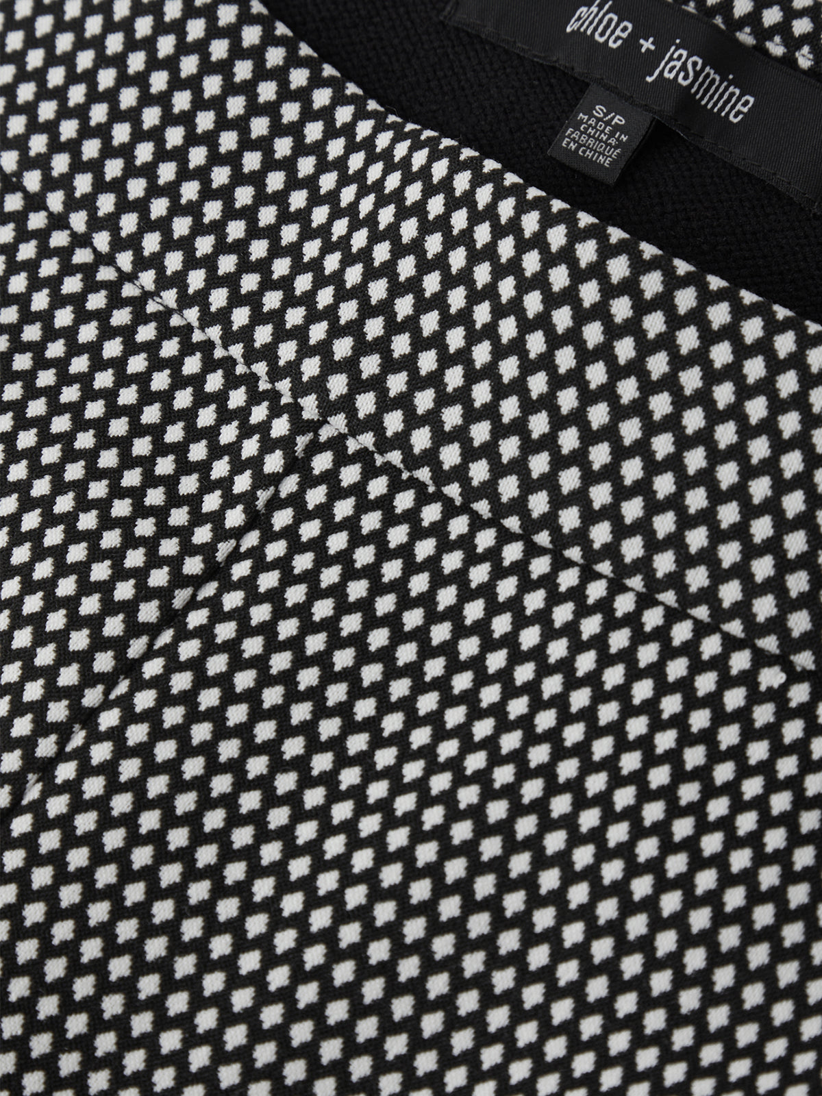 Close-up of a black and white patterned garment with a brand tag.