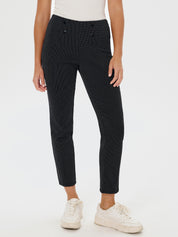 Person wearing black patterned pants and white sneakers on a white background