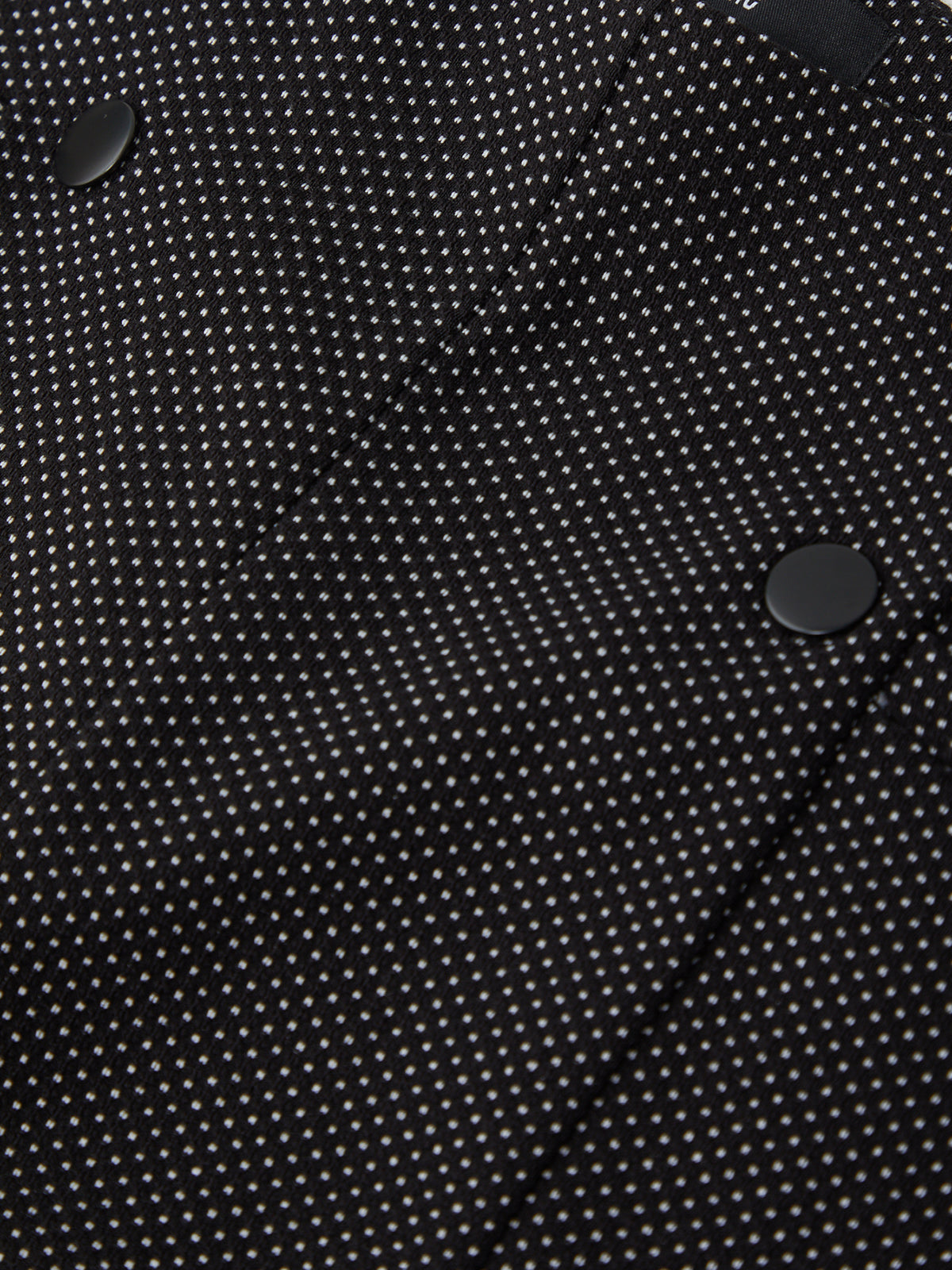 Close-up of a black fabric with white polka dots