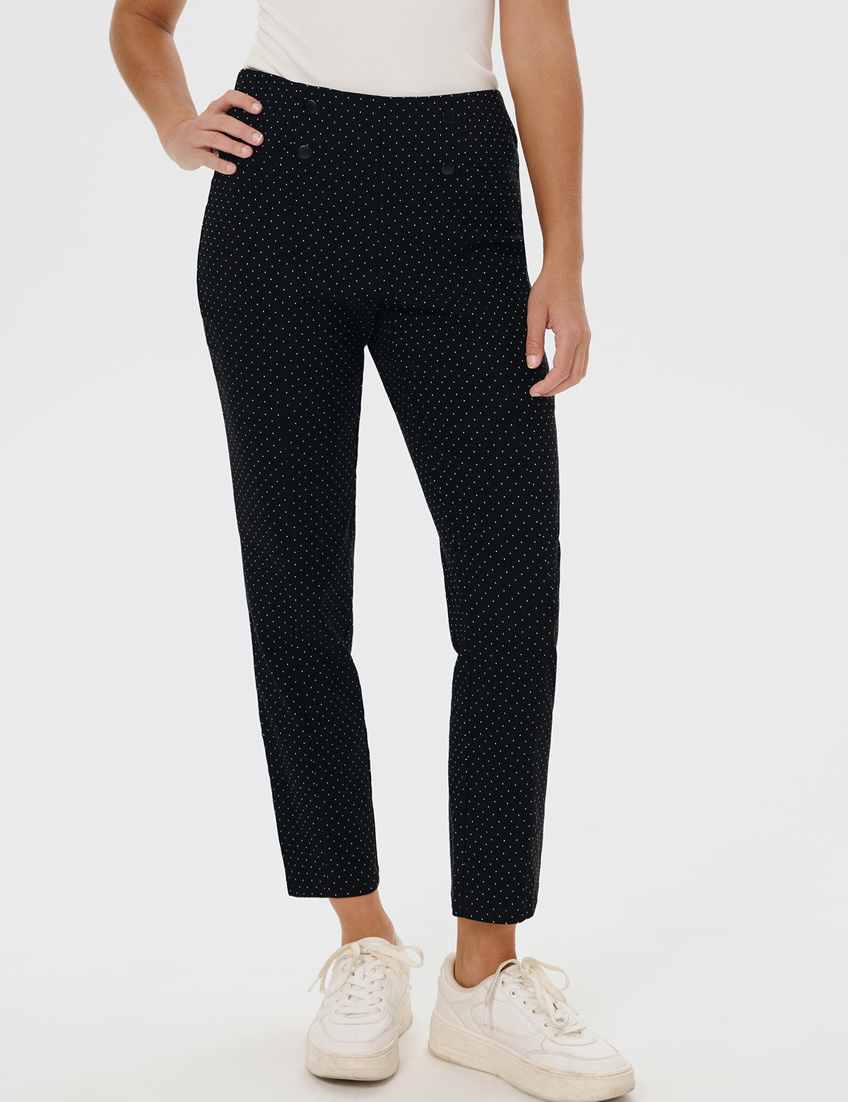 Person wearing black polka dot pants on a white background