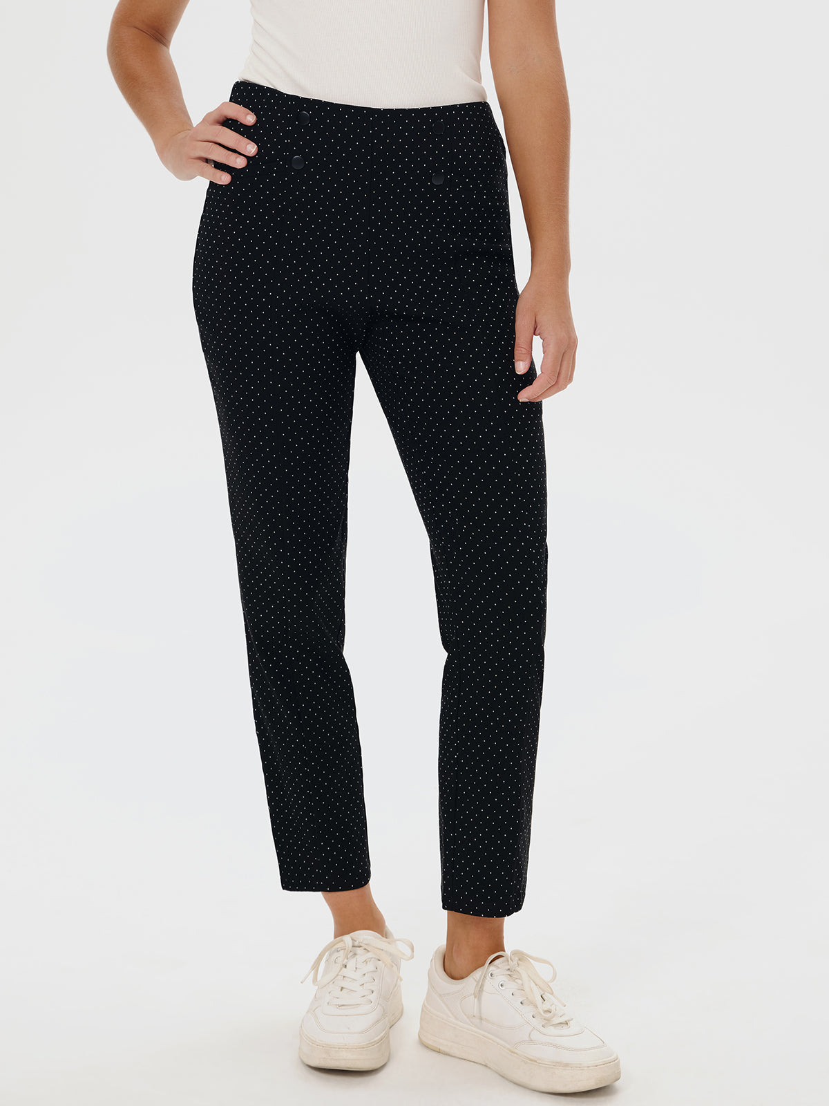 Person wearing black polka dot pants on a white background